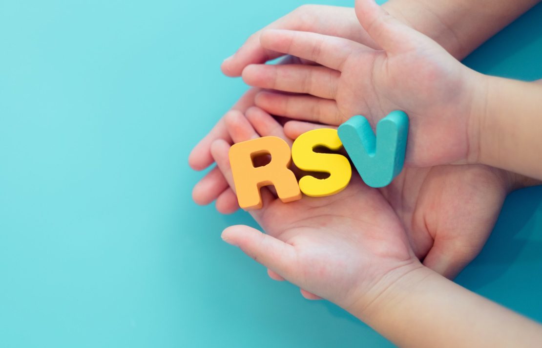 Deux paires de mains, une plus grande et une plus petite, tenant les lettres en couleur « R », « S » et « V » sur fond bleu pâle.