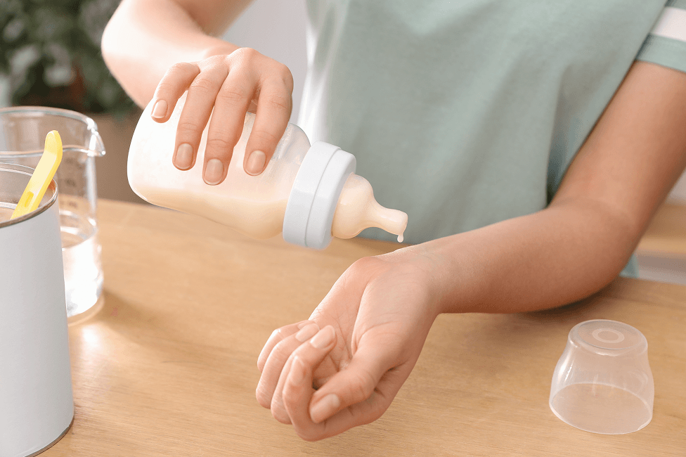 woman checking temperature of the infant formula