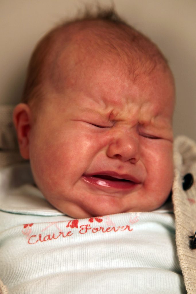 a baby with a grimace on their face