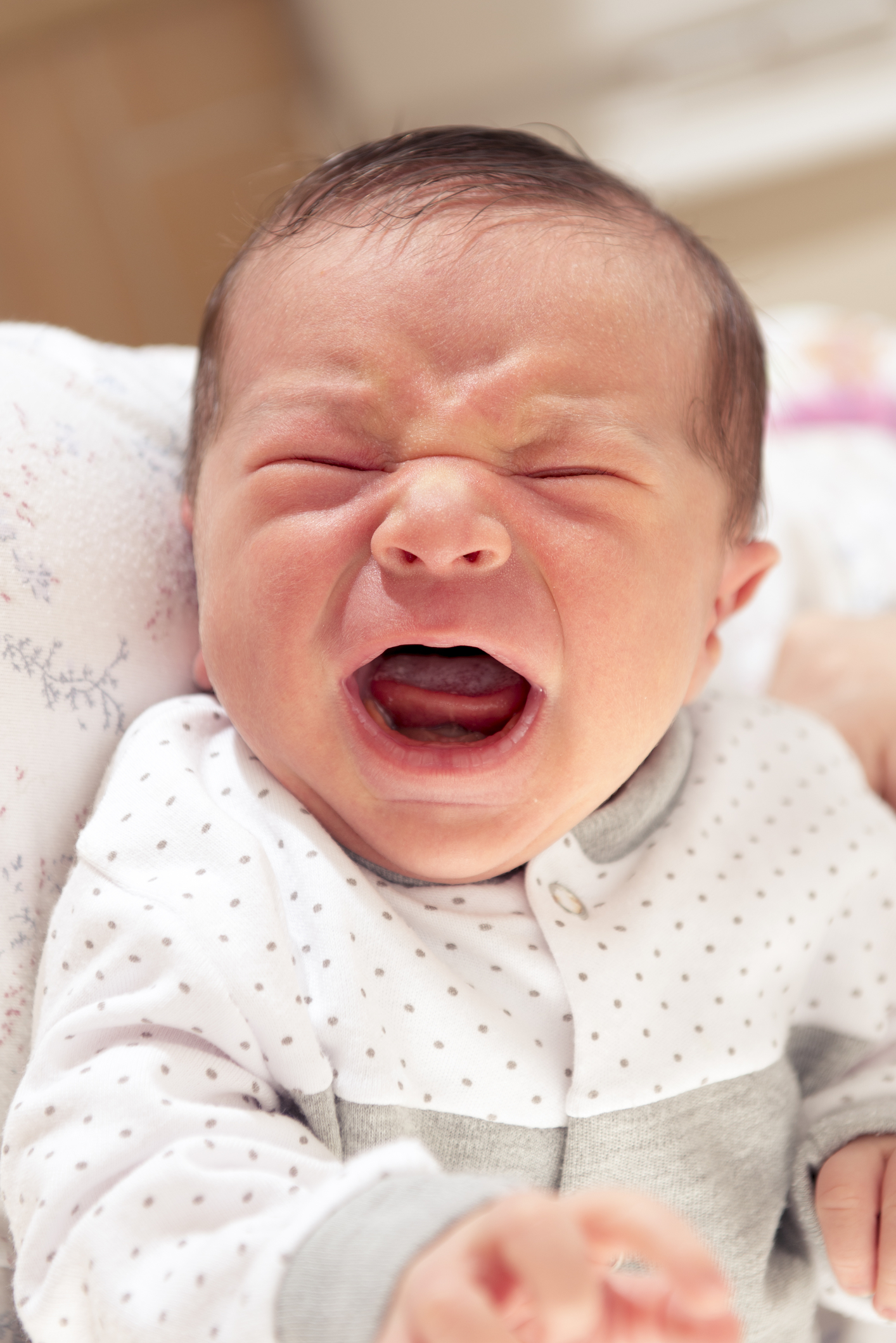 A close-up of a crying baby)