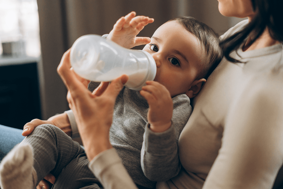 Parent qui nourrit son bébé à la préparation pour nourrissons.