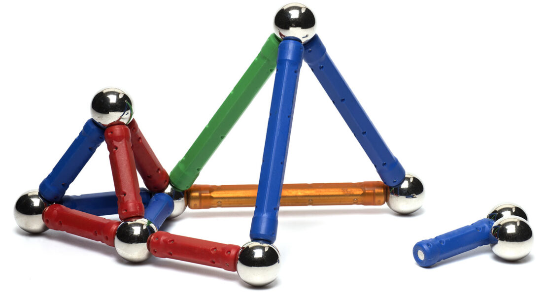 Des tiges de construction de couleur assemblées pour former une petite structure, avec des aimants circulaires à chaque coin