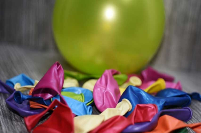 Ballons en latex non gonflés au premier plan et un ballon jaune gonflé à l’arrière-plan