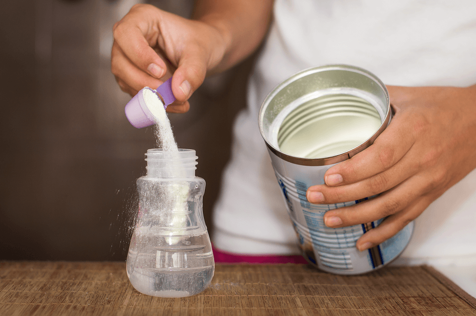 mother preparing powdered milk formula
