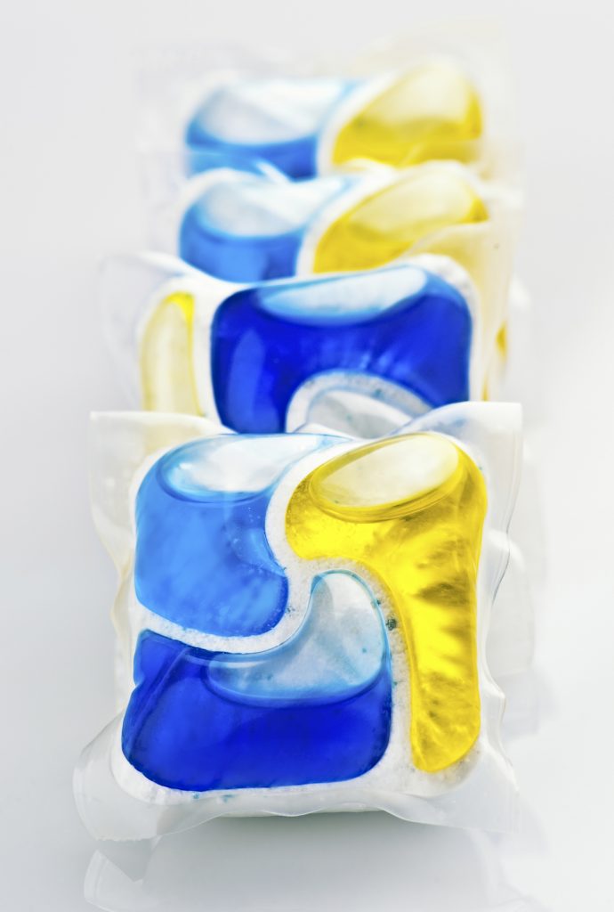 Quatre capsules de détergent jaune, bleue et blanche